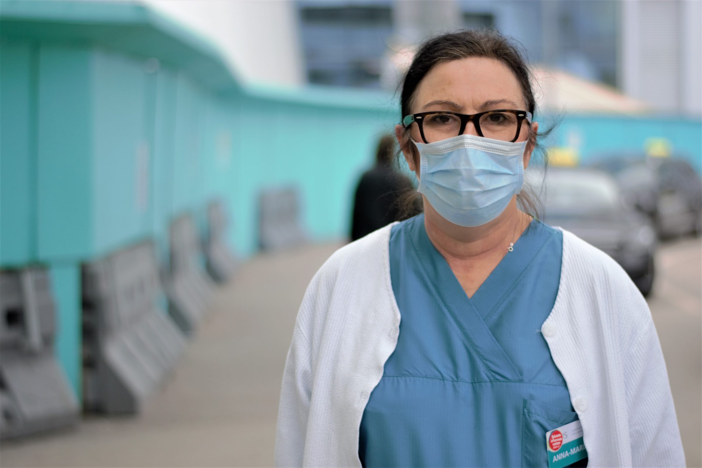sjukskötare med svart hår och ansiktsmask