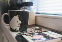 Kåserier är döda – det är ditt fel En kaffemugg bredvid en telefon på en köksyta.