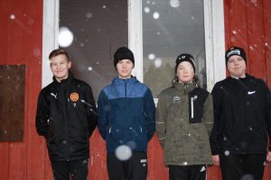 Rasmus Heikkilä, Albert Lindström, Melvin. Dahlbom och Sakarias Ek mot en röd husvägg.
