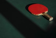 Restriktionerna lättas för hobbyverksamheten i Egentliga Finland Röd bordtennisracket på ett grönt bord.