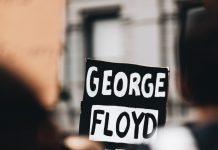 Derek Chauvin döms som skyldig i fallet George Floyd Plakat med George Floyds namn på i en folkmassa.