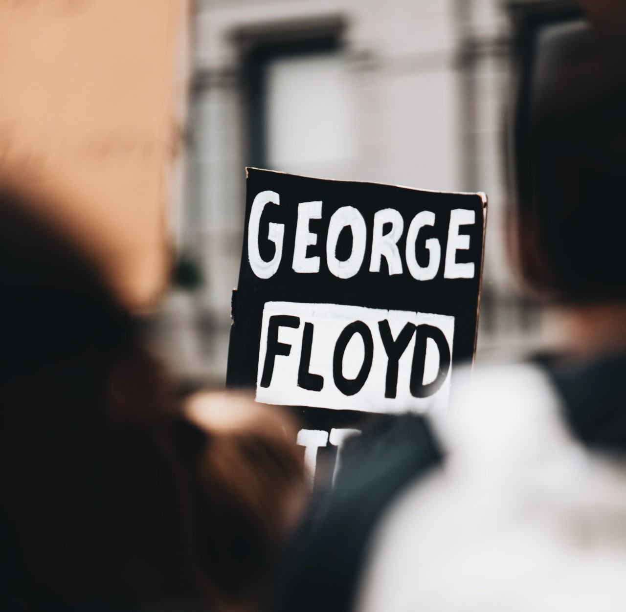Plakat med George Floyds namn på i en folkmassa.