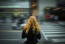 Unga uttrycker oro över säkerheten i Helsingfors Person med långt hår står på gatan med ryggen vänd mot kameran