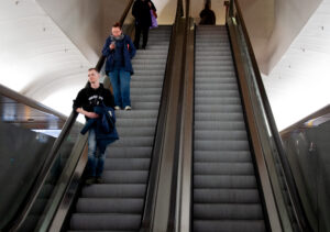 Tre människor åker ned i rulltrappor