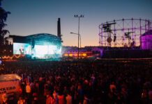 Flow Festival byter plats till 2024 På bilden är en scene där ett musikuppträdande pågår med en stor publik framför i festival området. Det är solnedgång.