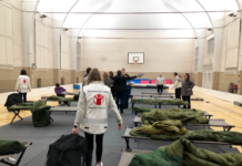 Fler kvinnor är redo då det blir kris – beredskapskurser mer populära än tidigare Kursdeltagare bygger akutboende i gymnastiksal på beredskapskurs. De monterar tältsängar och viker ut gröna sovsäckar. Kursledare ger instruktioner.