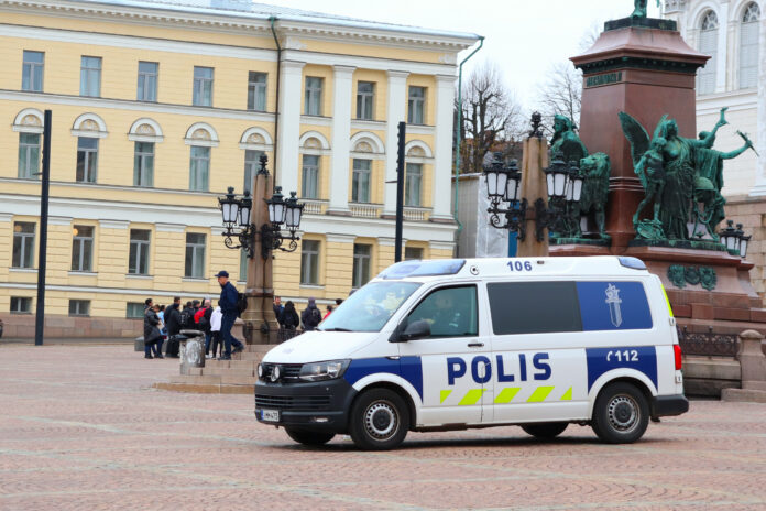 Det är en polisbil som är parkerad på ett torg i Helsingfors.