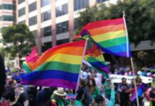 Smutsiga pengar skymmer regnbågen – vissa företag donerar till anti-hbtqi-politiker Två Pride regnbågsflaggor i en folkmassa